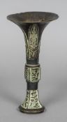 An antique Chinese patinated bronze stem vase The flared rim above geometrically decorated lappet