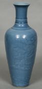 A Chinese porcelain vase Of slender form, with moulded dragon decoration and allover blue glaze,