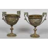 A pair of 19th century silvered bronze pedestal urns Each with twin mask headed handles,