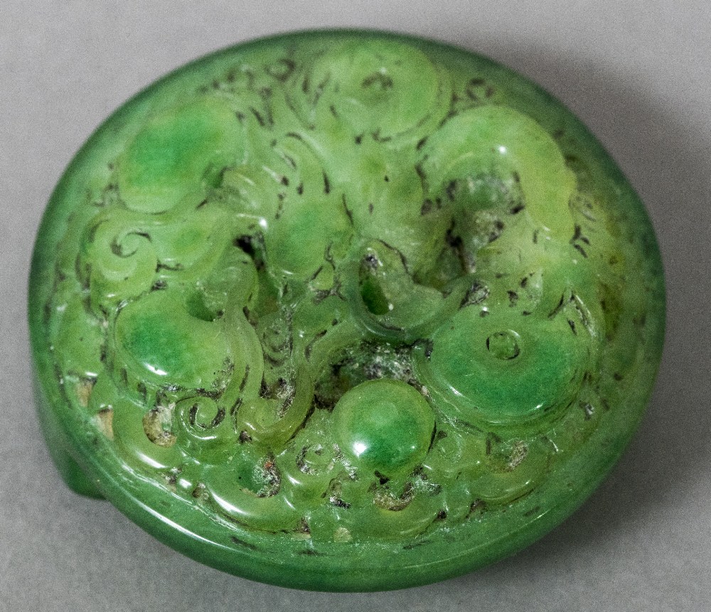 A Chinese carved jade belt hook Of circular form, carved with a dragon. 5.5 cm diameter.
