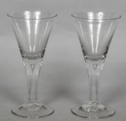 A pair of teardrop stem wine glasses With conical bowl and spreading foot. 19 cm high.