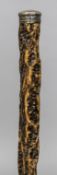 An unusual 19th century cork walking stick Mounted with a white metal knop handle. 84 cm long.