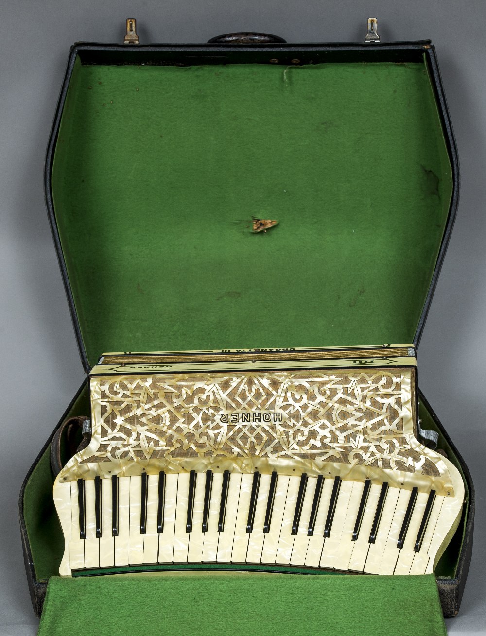 A Hohner Organetta III accordion Of typical form with mottled white casing,