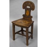 A 19th century mahogany hall chair The florally carved and inlaid shaped back above the inlaid