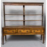 A George III oak dresser The open rack above three crossbanded drawers with brass handles above