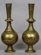A pair of Eastern brass vases Each decorated with embossed figural vignettes and engraved scrolls.