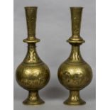 A pair of Eastern brass vases Each decorated with embossed figural vignettes and engraved scrolls.