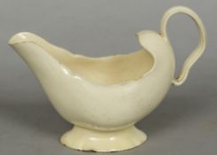 An 18th century creamware sauce boat Of silver form, standing on a spreading foot. 18.5 cm wide.