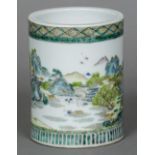 A Chinese famille verte brush pot Decorated in the round with villagers amongst a mountainous and