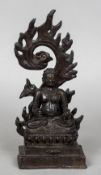 A Chinese patinated bronze model of a deity Seated in the lotus position before a detachable