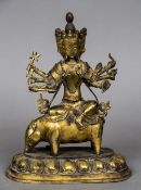 An Eastern bronze model of a three faced multi-armed deity Modelled holding various objects,