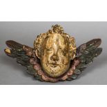A 17th/18th century carved polychrome painted winged cherub's bust 30 cm wide.