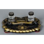 A 19th century papier mache inkstand Mounted with two carved hardwood topped glass inkwells and