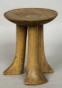 An Ethiopian carved wood stool The dished seat supported on splayed feet. 21.5 cm high.