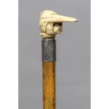 A Victorian ivory handled walking stick The handle formed as a dog wearing a nightcap. 88.