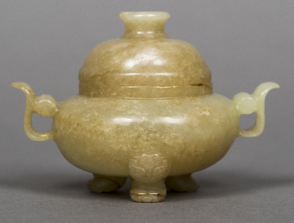 A Chinese carved pale and russet jade twin handled censor and cover Standing on lion mask headed