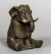 A late 19th/early 20th century novelty inkwell Formed as an elephant wearing a bib. 13.5 cm high.