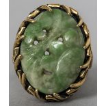 A carved and pierced jade set yellow metal ring CONDITION REPORTS: Generally in good