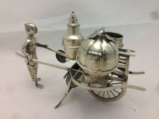 A late 19th/early 20th century Chinese Export silver condiment set Modelled as a Chinaman pushing a