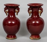 A pair of Chinese porcelain twin handled vases With allover sang de boeuf glaze,