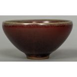A Chinese Jun ware bowl Of conical form with ox blood glaze. 9 cm diameter.