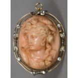 An unmarked yellow metal diamond set carved coral brooch Worked with the portrait bust of a young