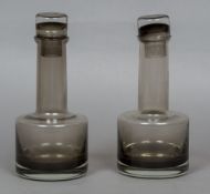 A pair of matched smoke grey glass decanters and stoppers by Per Lutken for Holmegaard