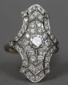 An Art Deco platinum diamond set ring Of pierced waisted navette form. 3 cm high.