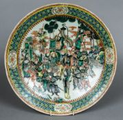 A Chinese famille verte porcelain charger Worked with a procession of warring figures. 41.