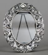 A small Chinese silver photograph frame Of pierced oval form,