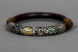 A Chinese unmarked white metal mounted wooden bangle Of circular form with calligraphic decorations.