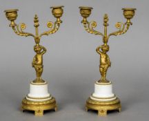 A pair of Empire gilt bronze and marble candelabra Each with scrolling twin branches above the