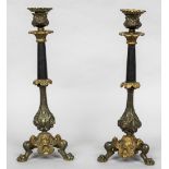 A pair of 19th century patinated and gilt bronze candlesticks Each with cast scrolling and figural