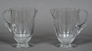 A pair of Lalique glass jugs Of plain form with beaded band, standing on a spreading foot,