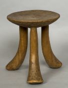 An Ethiopian carved wood stool The dished seat supported on splayed feet. 21 cm high.
