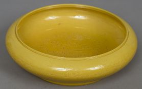 A Chinese porcelain bowl Incised with dragons chasing flaming pearls, on a yellow ground,