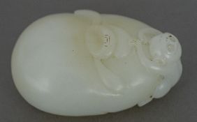 A Chinese carved white jade pebble Surmounted with the figure of a monkey. 5.5 cm wide.