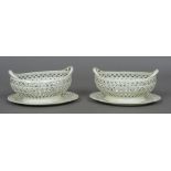 A pair of late 18th/early 19th century Staffordshire creamware twin handled baskets and stands,