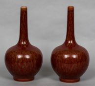 A pair of Chinese porcelain bottle vases Each with allover mottled ox blood glaze,