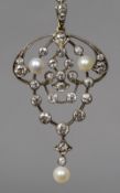 An unmarked gold Art Nouveau articulated diamond and pearl set pendant Of pierced scrolling foliate