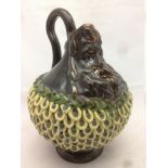 An unusual English pottery mask jug The baluster body with applied decoration and loop handle. 21.