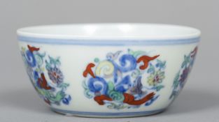 A Chinese porcelain Wucai tea bowl The exterior decorated with scrolling floral medallions,