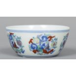 A Chinese porcelain Wucai tea bowl The exterior decorated with scrolling floral medallions,