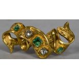 An unmarked gold, diamond and emerald set brooch Worked as ribbon. 3.5 cm wide.