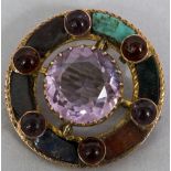 A 9 ct gold specimen stone and gem set brooch Of target form. 3.5 cm diameter.