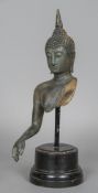 An antique patinated bronze bust and part torso modelled as Buddha Wearing a headdress,