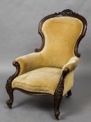 A Victorian mahogany framed spoon back armchair The scroll carved top rail above the padded back