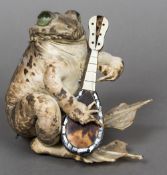 A preserved taxidermy toad Modelled seated playing a tortoiseshell veneered mandolin. 13 cm high.