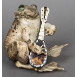 A preserved taxidermy toad Modelled seated playing a tortoiseshell veneered mandolin. 13 cm high.