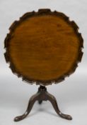 A 19th century mahogany tilt top tripod table The shaped folding top above the turned column,